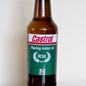 Op de afbeelding: Een bruine glazen fles Castrol R30 racemotorolie met een groen etiket en een gouden dop.