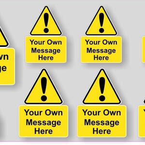 Peut inclure: Huit panneaux d'avertissement jaunes avec des points d'exclamation noirs et le texte "Your Own Message Here" imprimé sur chaque panneau.