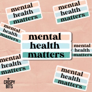 May include: Six stickers with the text "mental health matters" in black text on a background of pink, blue, and green stripes. The stickers are arranged in a random pattern on a pink background.
