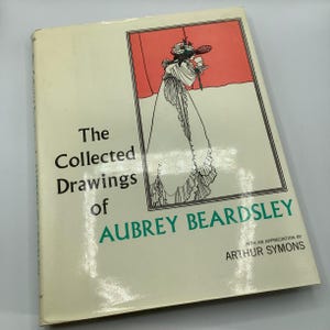 May include: A vintage book titled "The Collected Drawings of Aubrey Beardsley" with an illustration of a woman in a long dress. The cover is off-white with black and green text and a red and black framed illustration.
