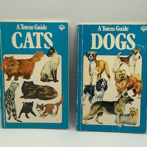 May include: Two vintage books titled "A Totem Guide" with blue covers. One book features illustrations of various cat breeds, and the other showcases different dog breeds. The titles are in white block letters.