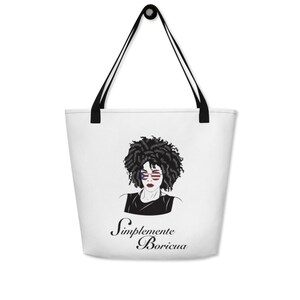 May include: White tote bag with a black handle. The bag features a black and white illustration of a woman with an afro wearing sunglasses with the American flag design. The text "Simplemente Boricua" is written in black cursive below the illustration.
