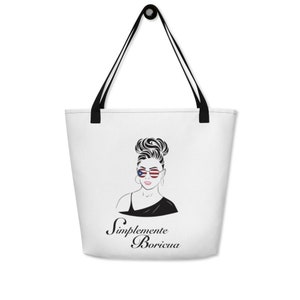 May include: White tote bag with a black handle and a black and white illustration of a woman with a bun in her hair wearing sunglasses with the Puerto Rican flag on them. The text "Simplemente Boricua" is written below the illustration.