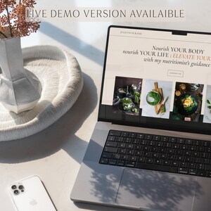 Może przedstawiać: Laptop z wyświetlaną stroną internetową dietetyka. Strona zawiera tekst "Nourish YOUR BODY nourish YOUR LIFE: ELEVATE YOUR HEALTH with my nutritionist's guidance". Strona zawiera r&oacute;wnież cztery zdjęcia zdrowej żywności.