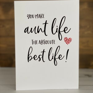 May include: White card with black text that reads "You make aunt life the absolute best life!" with a red glitter heart.