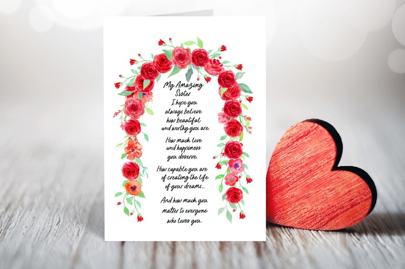 May include: A card with a watercolor floral design of red roses and green leaves. The card has a message that reads "My Amazing Sister I hope you always believe how beautiful and worthy you are. How much love and happiness you deserve. How capable you are of creating the life of your dreams... And how much you matter to everyone who loves you."