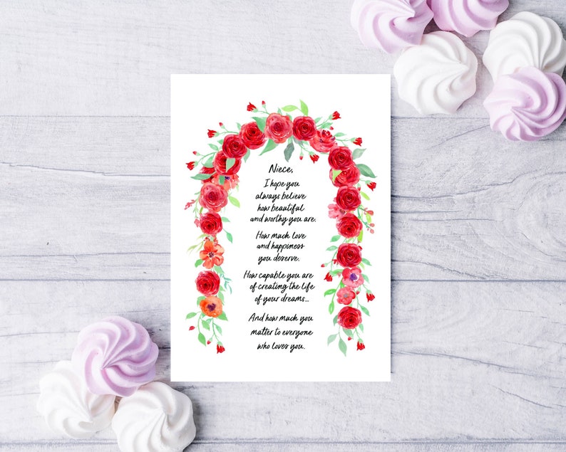 May include: A white card with a red floral border and a handwritten message that reads: "Nieces, I hope you always believe how beautiful and worthy you are. How much love and happiness you deserve. How capable you are of creating the life of your dreams... And how much you matter to everyone who loves you."