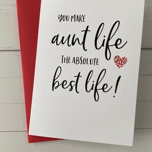 May include: A white card with black text that reads "You make aunt life the absolute best life!" with a red glitter heart.