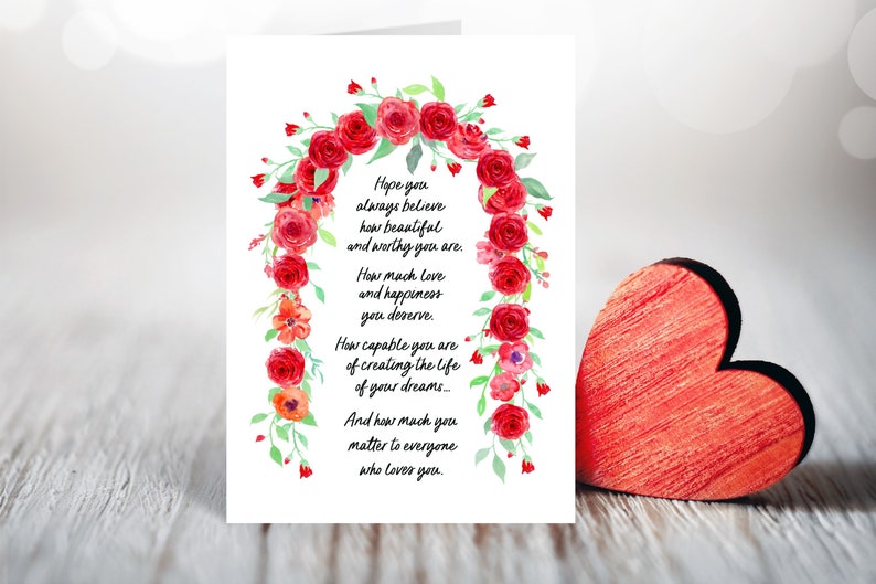 May include: A white card with a watercolor illustration of a red rose garland. The card has a message that reads: "Hope you always believe how beautiful and worthy you are. How much love and happiness you deserve. How capable you are of creating the life of your dreams... And how much you matter to everyone who loves you."