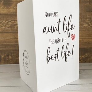 May include: White card with black text that reads "You make aunt life the absolute best life!" with a red glitter heart.