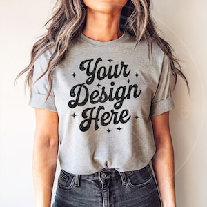 May include: A heather grey t-shirt with a black graphic that says "Your Design Here" with stars around the text.