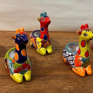Puede incluir: Cinco macetas de cerámica de jirafa de colores con diseños florales pintados. Cada maceta tiene una maceta pequeña para plantar una pequeña suculenta u otra planta.
