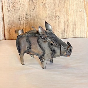 Könnte beinhalten: Eine Metallsculptur eines Wildschweins, hergestellt aus recyceltem Metall. Die Skulptur ist in Grautönen und Braun bemalt und hat ein realistisches Aussehen.