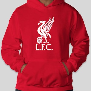 May include: A red hooded sweatshirt featuring a white emblem of a bird holding a ball, with the letters "L.F.C." below. The sweatshirt has a kangaroo pocket and a drawstring hood.