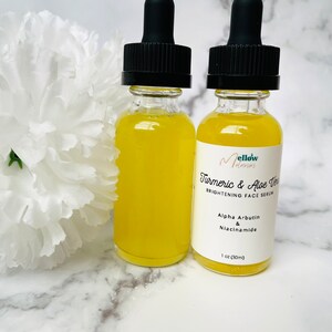Puede incluir: Dos botellas de vidrio &aacute;mbar con goteros llenas de un l&iacute;quido amarillo. Las botellas est&aacute;n etiquetadas con "Mellow Moments Turmeric & Aloe Vera Brightening Face Serum" con los ingredientes "Alpha Arbutin & Niacinamide" y "1 oz (30ml)".