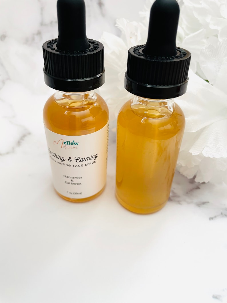 Pu&ograve; includere: Due bottiglie di vetro ambrato con tappi contagocce neri riempite di un liquido giallo chiaro. Le bottiglie sono etichettate "mellow interior Soothing & Calming Hydrating Face Serum Niacinamide & Oat Extract 1 fl oz (30ml)"
