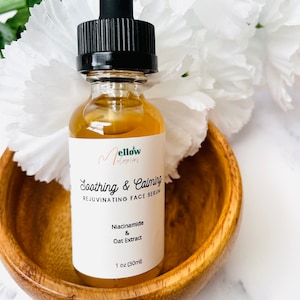 Pu&ograve; includere: Una bottiglia di vetro trasparente con un contagocce nero e un'etichetta bianca. L'etichetta dice "Mellow Melodies" e "Soothing & Calming Rejuvenating Face Serum". Gli ingredienti elencati sono "Niacinamide & Oat Extract". La bottiglia contiene 30 ml di siero.
