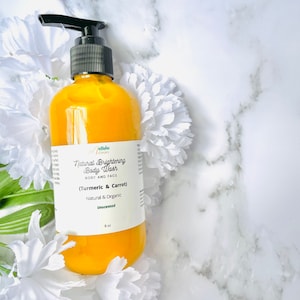 May include: A yellow plastic bottle of unscented natural brightening body wash with turmeric and carrot. The bottle is labeled "Yellow Bloom Natural Brightening Body Wash (Turmeric & Carrot) Natural & Organic Unscented 8 oz."