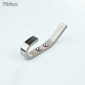 以下が含まれることがあります： カーブしたデザインのつや消しニッケル壁掛けフック。フックには2つのネジ穴があり、左上隅に「Vision」の文字が印刷されています。フックは金属製で、物を吊るすように設計されています。