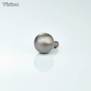 May include: A brushed metal cabinet knob with a spherical design and a cylindrical stem. The knob is a muted silver color and reflects the light. The word "Vision" is in the upper left corner.