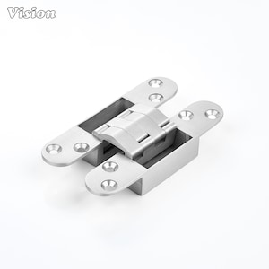 Pode incluir: Uma dobradiça oculta de metal prateado com uma base retangular e duas placas de montagem planas com quatro orifícios para parafusos escareados. A ferragem tem um acabamento escovado e um mecanismo de pivô central para portas.