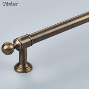 May include: A cylindrical cabinet handle with a brushed antique bronze finish. The hardware features a spherical finial at the end, a central rod, and a single mounting post with a circular base. The word Vision is printed in the top left corner.