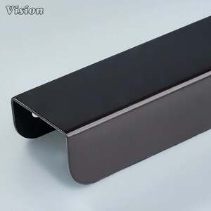 May include: A dark brown metal object with a rectangular shape and rounded edges. The word "Vision" is in the upper left corner. The object appears to be a piece of hardware or a component of a larger structure.