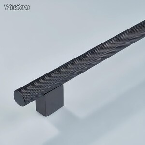 May include: A black cabinet pull with a textured, diamond-patterned handle. The handle is cylindrical and attached to a square base. The word "Vision" is in the upper left corner.