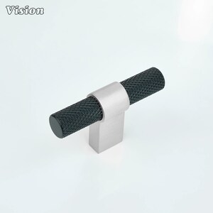 May include: A cabinet pull with a black, textured handle and a brushed silver base. The handle is cylindrical and has a diamond pattern. The word "Vision" is in the upper left corner.