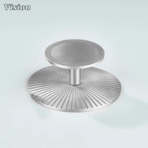 Peut inclure: Un bouchon de bouteille en métal brossé avec un dessus circulaire et une base avec un design rainuré radial. Le mot "Vision" est dans le coin supérieur gauche.