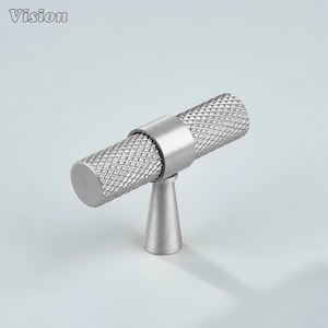 May include: A silver-toned cabinet knob with a diamond-patterned cylindrical handle and a conical base. The knob is made of metal and has a modern, minimalist design. The word "Vision" is in the top left corner.