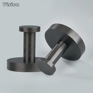 Könnte beinhalten: Zwei dunkelgraue Metall-Wandhaken. Jeder Haken hat eine kreisförmige Basis und einen zylindrischen Pfosten, der von einem kleineren kreisförmigen Kopf gekrönt wird. Die Haken bestehen aus gebürstetem Metall.