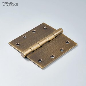 May include: A bronze-colored door hinge with a rectangular shape and rounded edges. The hinge has multiple screw holes and a cylindrical barrel in the center. The word "Vision" is in the top left corner.