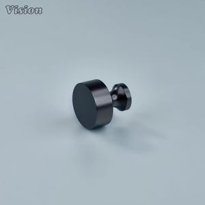 May include: A black cabinet knob with a cylindrical body and a rounded handle. The word "Vision" is in the upper left corner. The knob is made of a dark, matte material against a light blue background.