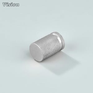 May include: A silver-colored, cylindrical knob with a textured, diamond-patterned grip. The knob has a flat, circular end and a slightly raised, ridged edge. The word "Vision" is printed in the upper left corner.
