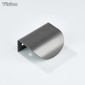 Peut inclure: Une poignée de meuble en métal brossé de couleur gris foncé, avec un design incurvé en demi-lune. La poignée a un petit trou sur le côté. Le mot "Vision" est imprimé en haut à gauche.