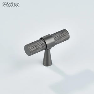 May include: A dark gray cabinet pull with a diamond pattern on the handle. The pull has a cylindrical handle and a conical base. The word "Vision" is in the top left corner.
