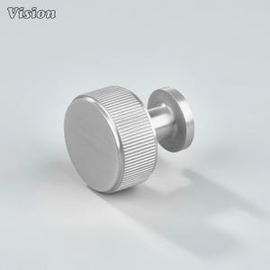 May include: A brushed silver cabinet knob with a round, ridged grip and a flat, circular base. The word "Vision" is in the upper left corner. This hardware is suitable for drawers and cabinets.
