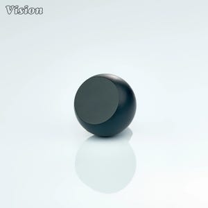 Puede incluir: Una esfera azul oscuro con una incrustación circular gris. La palabra "Vision" está en la esquina superior izquierda. El objeto se refleja en una superficie blanca.