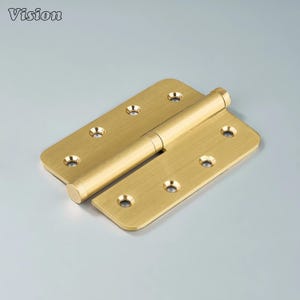 May include: A brass door hinge with rounded corners and six screw holes on each leaf. The hinge is open, showing the cylindrical barrel connecting the two leaves. The word "Vision" is in the upper left corner.