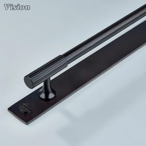 Pode incluir: Uma puxador de porta preto com uma pega cilíndrica e uma base retangular. A pega tem uma textura canelada e é montada numa base preta com um parafuso. A palavra "Vision" é visível.