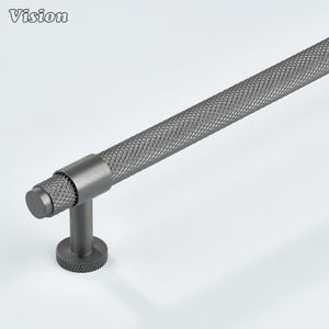 May include: A grey cabinet pull with a textured, diamond-patterned handle. The pull has a cylindrical design with a round base and a short stem. The word "Vision" is in the top left corner.