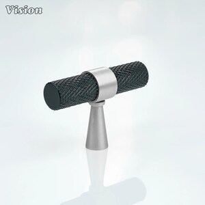 May include: A cabinet pull with a textured, dark gray cylindrical handle and a silver-colored base. The handle is held in place by a silver-colored ring. The word "Vision" is in the top left corner.