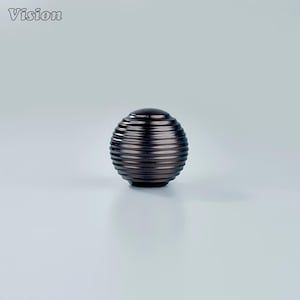 May include: A dark bronze-colored, spherical cabinet knob with a grooved, textured surface. The knob has a rounded top and a solid base. The word "Vision" is in the upper left corner.