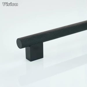 May include: A black cabinet pull with a textured, cylindrical handle and a square base. The handle has a diamond pattern. The word "Vision" is in the upper left corner.