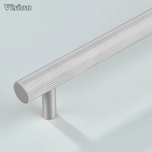 以下が含まれることがあります： 溝付き円筒形ハンドルと丸いポストを備えたシルバーのキャビネットプル。左上隅に「Vision」の文字。金具は金属製で、家具用に設計されています。