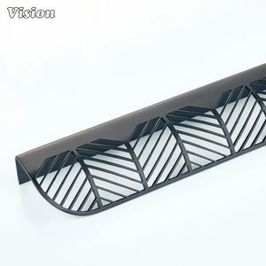 Peut inclure: Une poignée de meuble en métal noir avec un motif en forme de feuille. La poignée a une forme incurvée avec une série de lignes obliques créant un motif géométrique. Le mot "Vision" est dans le coin supérieur gauche.