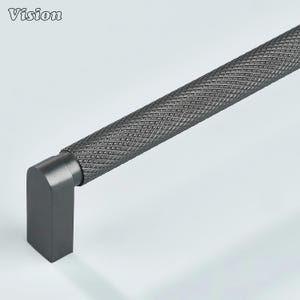 May include: A dark gray cabinet pull with a diamond pattern on the handle. The handle is cylindrical and connects to a square, right-angled base. The word "Vision" is in the upper left corner.