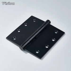 May include: A black door hinge with a matte finish. The hinge is rectangular with rounded corners and has multiple screw holes. The hinge is open, revealing the cylindrical pin. The word "Vision" is in the upper left corner.