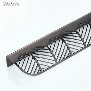 May include: A dark grey cabinet pull with a leaf design. The metal pull has a curved shape. The word "Vision" is in the top left corner.